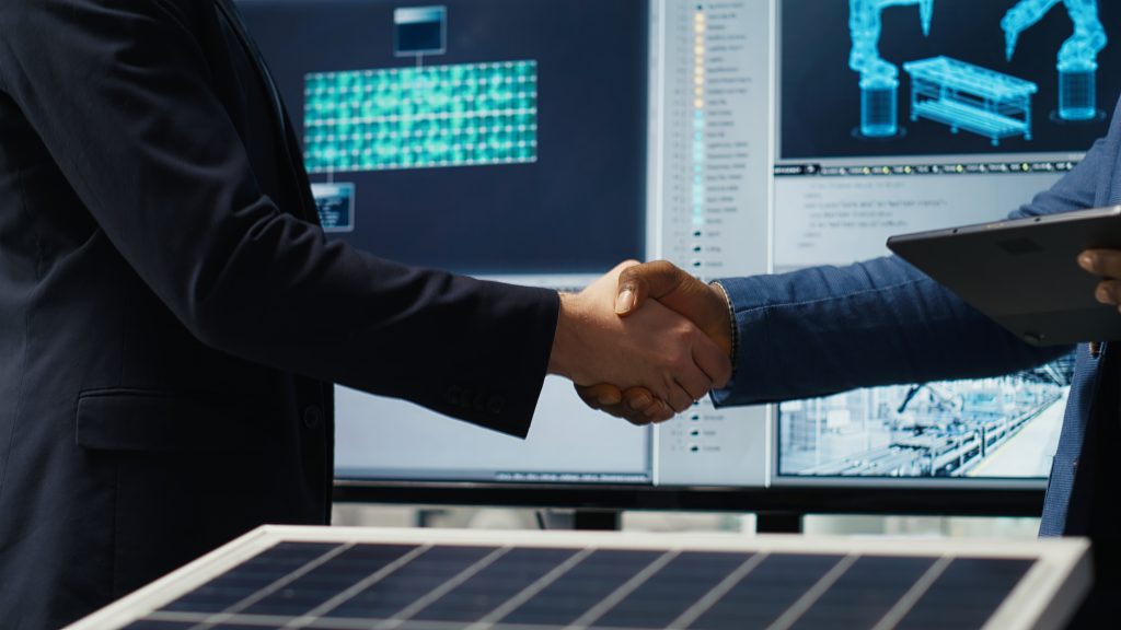 factory manager shakes hands with investor, working to expand production